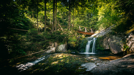 wooden bridge in the forest with waterfall