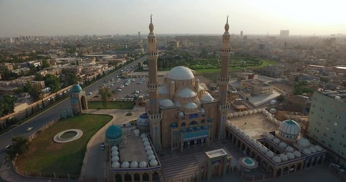 shot from left to right of a large mosque with domes and beacons