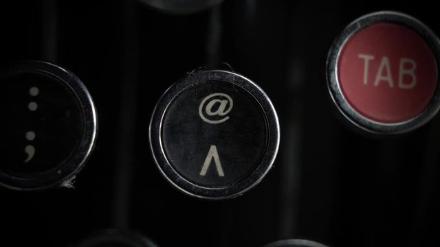 Macro close up of the "at" and ^ keys on an old Remington Rand Model 1 Typewriter.