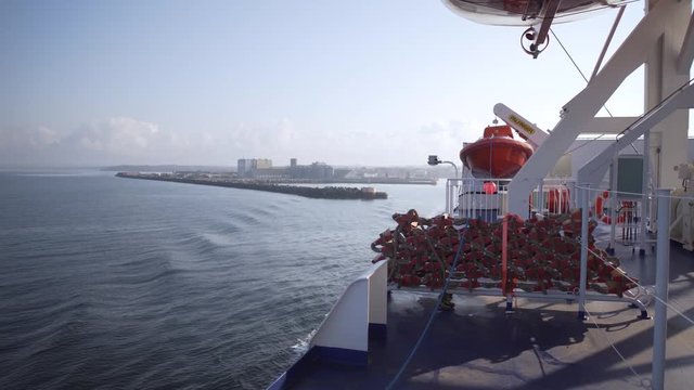 Red rescue belt on a white ferry with ocean in the background.