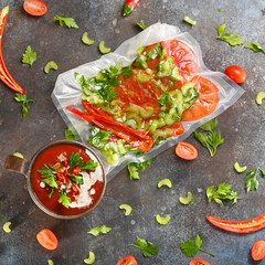 Red tomato soup in copper cup on dark background. Squared .
