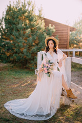 Fototapeta premium cowboy style bride stands near fence on ranch