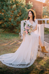 Fototapeta na wymiar cowboy style bride stands near fence on ranch