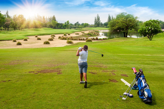 13-year-old Asian boy playing golf on a golf course in the sun - Image