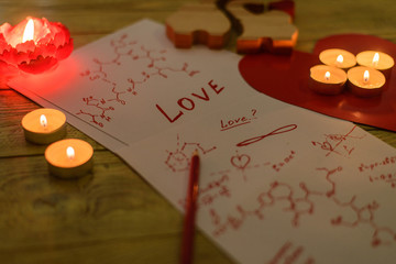 Formula love concept. Research, search for an answer to the question: what is love. Sheets of paper with chemical formulas of hormones by candlelight.