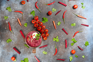 Red beet vegetarian soup in copper cup on dark background.