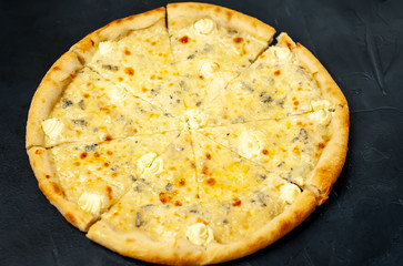 Delicious four cheese pizza on a concrete background. Top view of hot pizza. 