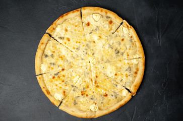Delicious four cheese pizza on a concrete background. Top view of hot pizza. 