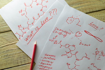The concept of love as hormones. Sheets of paper written with formulas in search of an answer to...