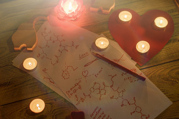 Formula love concept. Research, search for an answer to the question: what is love. Sheets of paper with chemical formulas of hormones by candlelight.