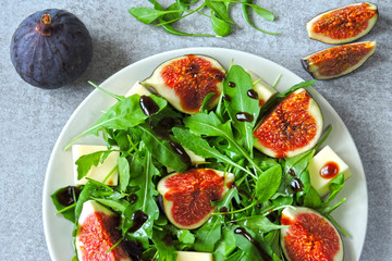 Fresh juicy salad with figs, arugula and white cheese. Healthy colorful fitness salad. Superfoods