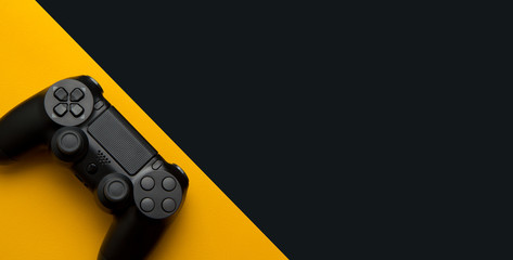 black wireless gamepad on a black and yellow background