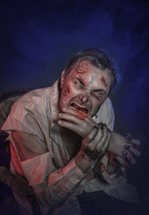 Horror terrible zombie man eating hand. Halloween scene