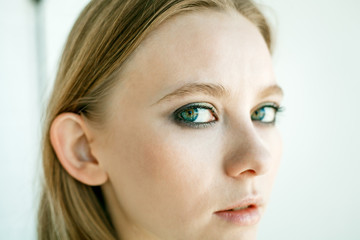 Obraz premium Face of a teenage girl close-up on a white background. The concept is a serious look or emotion.