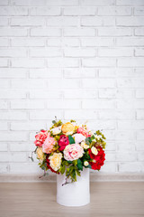 beautiful bunch of summer flowers in round box over white wall background with copy space