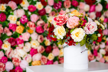 close up of summer bouquet of flowers in vase on the table over colorful background