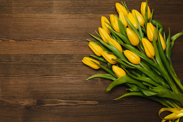 Bouquet of yellow tulips on wooden table 
