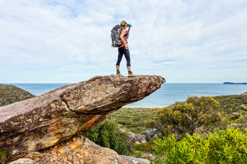 Obraz premium Hiker on rock cliff precipice with views