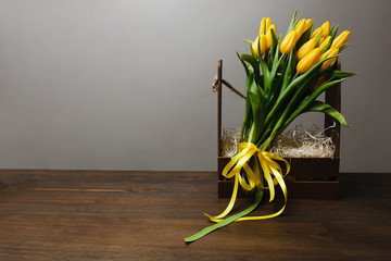 The bouquet of yellow tulips in the wooden box with copy space for your text