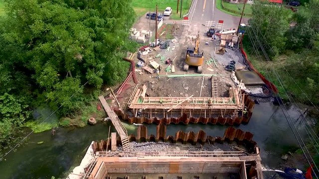 Aerial push in on Lititz Run bridge construction workers Lancaster County Pennsylvania.Concept: renewal, building, men working, construction, public-private partnership, infrastructure