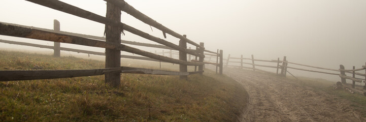 Fototapeta premium Dirt road in the fog in autumn