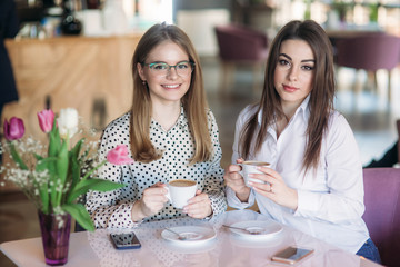 Girls use their break from work to drink coffee and chat. Caffe cappuccino.