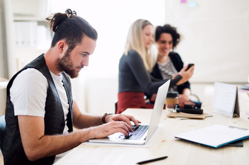 Group of young businesspeople with laptop working in a modern office.