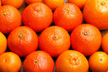 whole tangerine on the table with drops of water on the peel