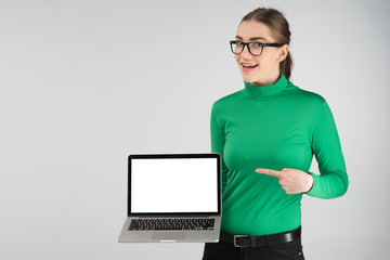 Happy girl holds a laptop and pointing to a screen. -- Image