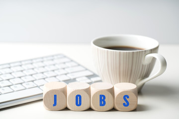 Würfel mit Aufschrift JOBS vor einer Tastatur 