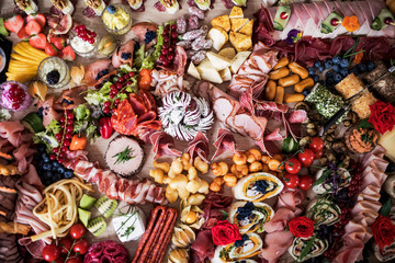 Fototapeta na wymiar A top view of various food and snacks on a tray on a indoor party, a cold buffet.