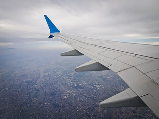 Fototapeta premium View from the window of an airplane taking off with a wing - a flight over the city.