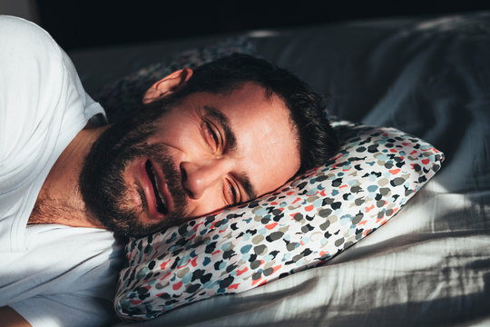 Young Depressed Man Crying In Bed