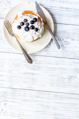 Breakfast concept with flowers on wooden background top view