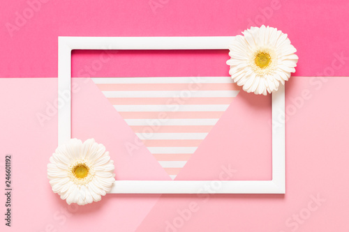Happy Mother's Day, Women's Day, Valentine's Day or Birthday Pastel Pink Background. Flat lay mock up greeting card with beautiful gerbera flowers and picture frame.