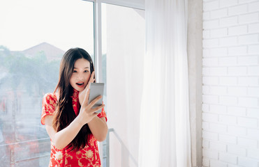 Asian Woman Chinese dress,Qipao,Cheongsam Shocked Product Sale of Chinese New Year Day Shopping Online on Mobile or Smartphone,Copy Space.