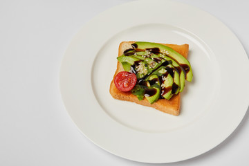 top view of toast with avocado and cherry tomato on grey backgroud