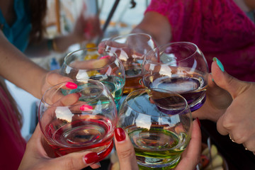 Company of women hold colored glasses or tumbler, holiday on the yacht