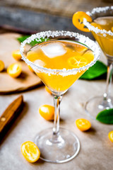 cocktail with kumquat on wooden background
