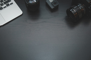 GoPro, MacBook Air, camera lens on lights on dark wooden desk