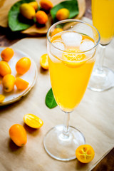 cocktail with kumquat on wooden background