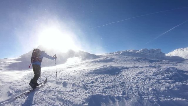Young adult confronting extreme weather while ascending on his splitboard