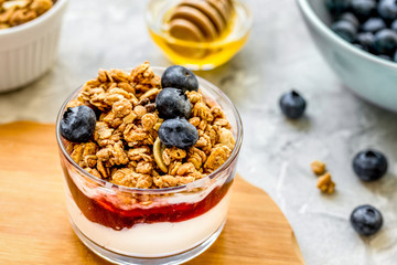 Healthy breakfast from yoghurt with muesli and berries on kitchen table