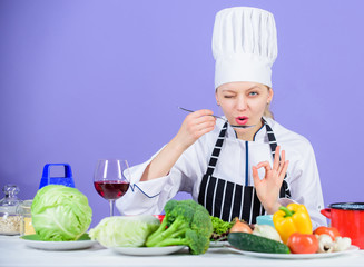 Girl in hat and apron. Cooking healthy food. Fresh vegetables ingredients for cooking meal. Professional cooking tips. Woman chef try taste food. Gourmet main dish recipes. Delicious recipe concept