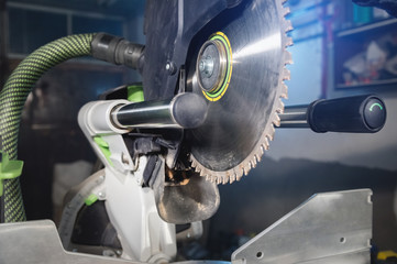 Close-up manual circular saw on slides for sawing wood in the home workshop