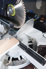 Close-up manual circular saw on slides for sawing wood in the home workshop