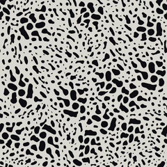Black animal skin leopard pattern on light background. Seamless background with random black elements. Abstract ornament.