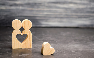 A miniature couple in love and a heart near them. The concept of family problems and loss of...