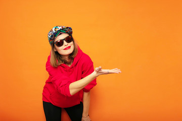 young girl in red hoodie on orange background