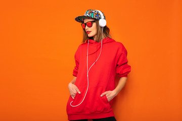 cool hipster girl with colored hat on orange